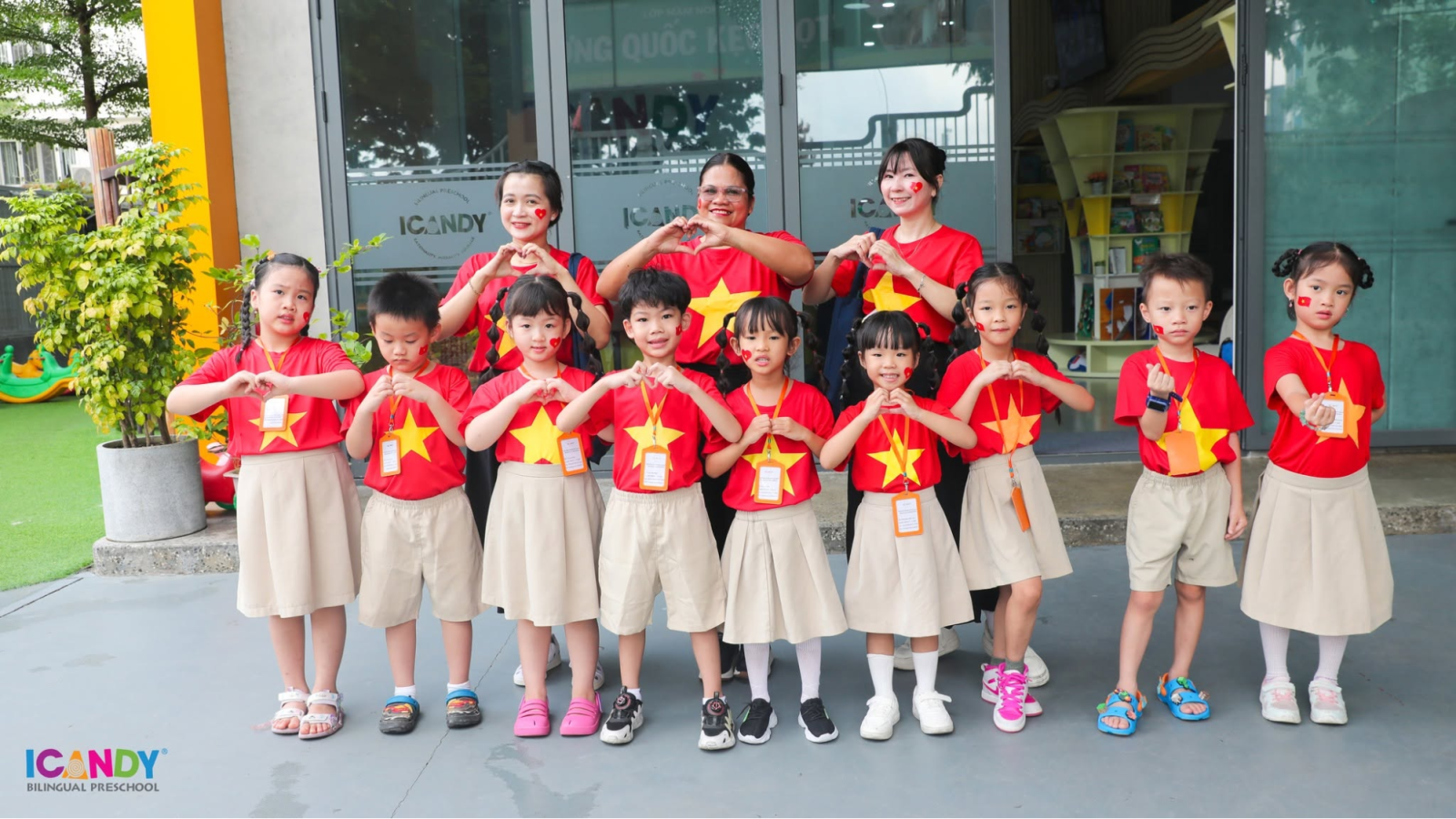 Tập thể cô trò ICANDY Preschool rạng rỡ trong trang phục cờ đỏ sao vàng tại sân trường