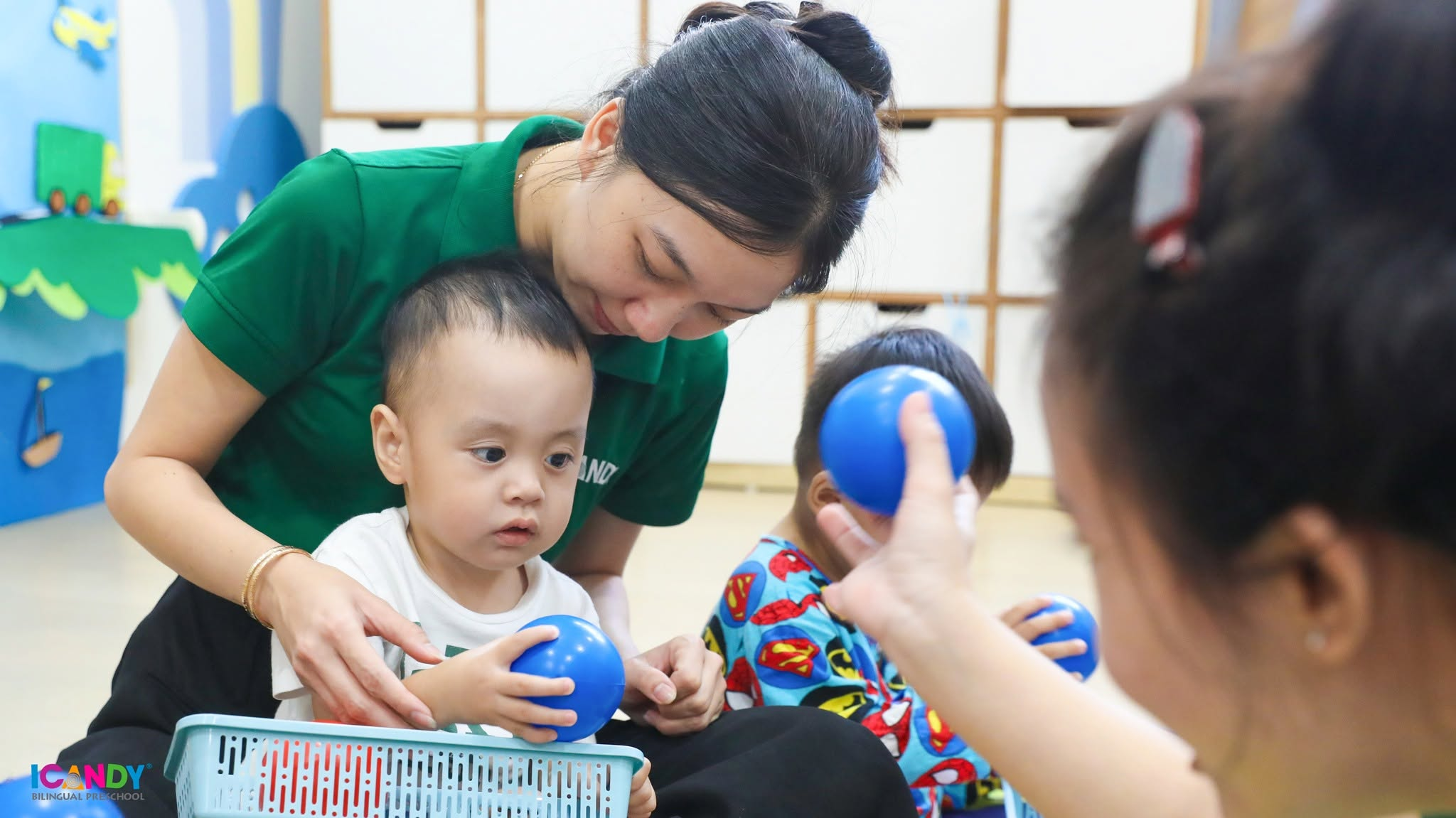 CC&ocirc; gi&aacute;o &acirc;n cần hướng dẫn b&eacute; nhận biết m&agrave;u sắc v&agrave; tập thả b&oacute;ng nhựa tại lớp học