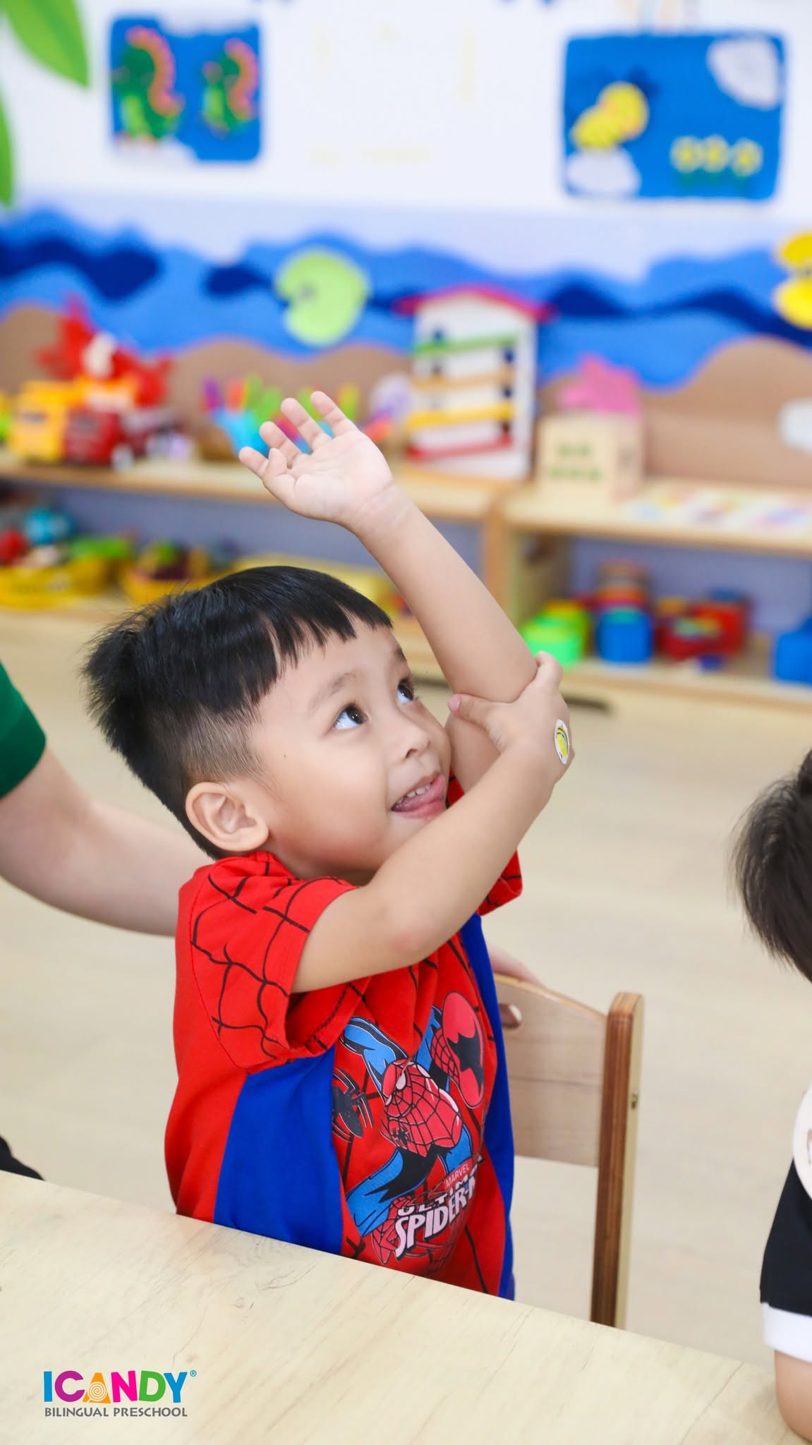 B&eacute; trai h&agrave;o hứng giơ tay ph&aacute;t biểu s&ocirc;i nổi trong giờ học vui nhộn tại lớp mầm non