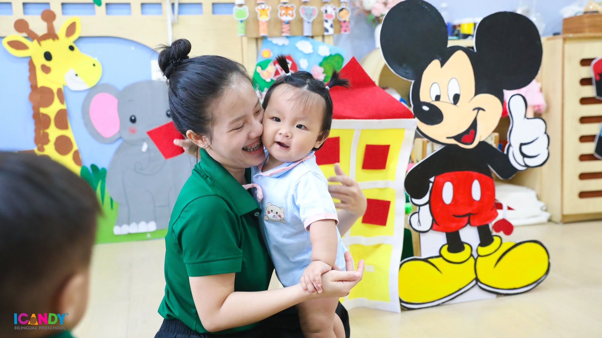 Cô giáo âu yếm ôm em bé lớp nhà trẻ tại trường mầm non song ngữ ICANDY Bình Thạnh