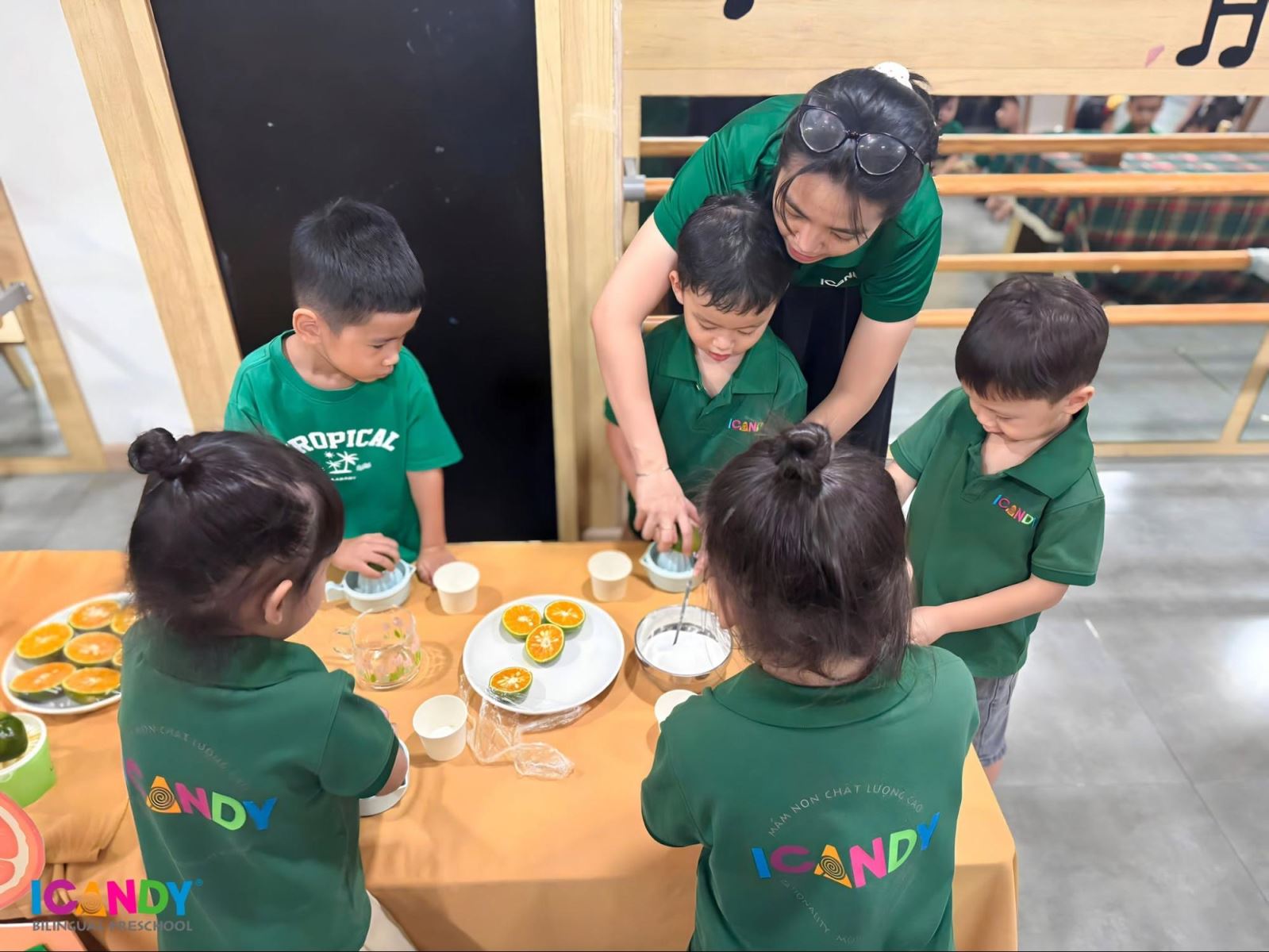 Các bé vắt nước cam dưới sự hướng dẫn của giáo viên ICANDY